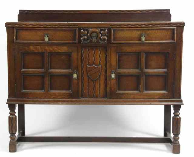 Appraisal: An oak sideboard fitted three frieze drawers above two cupboard