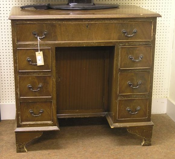 Appraisal: A reproduction mahogany kneehole desk cross banded top above single