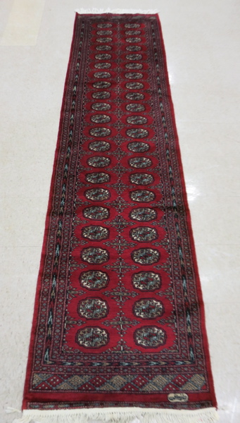 Appraisal: SIGNED RED FIELD BOKHARA RUNNER India or Pakistan hand knotted