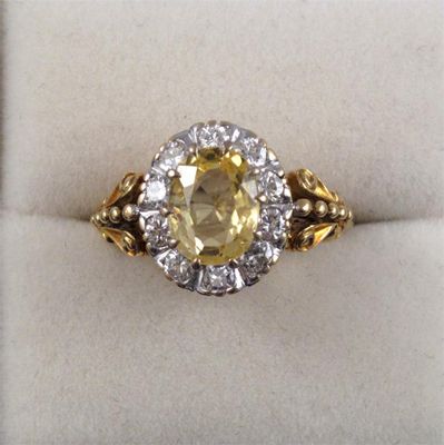 Appraisal: A yellow sapphire and diamond cluster ring The oval shaped