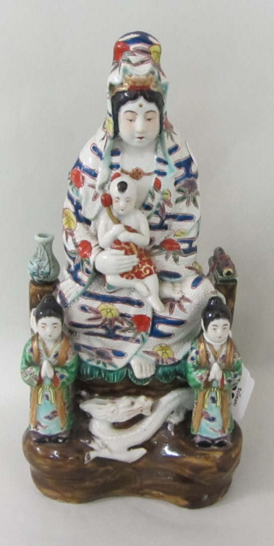 Appraisal: A Japanese porcelain group of Kannon circa seated holding a