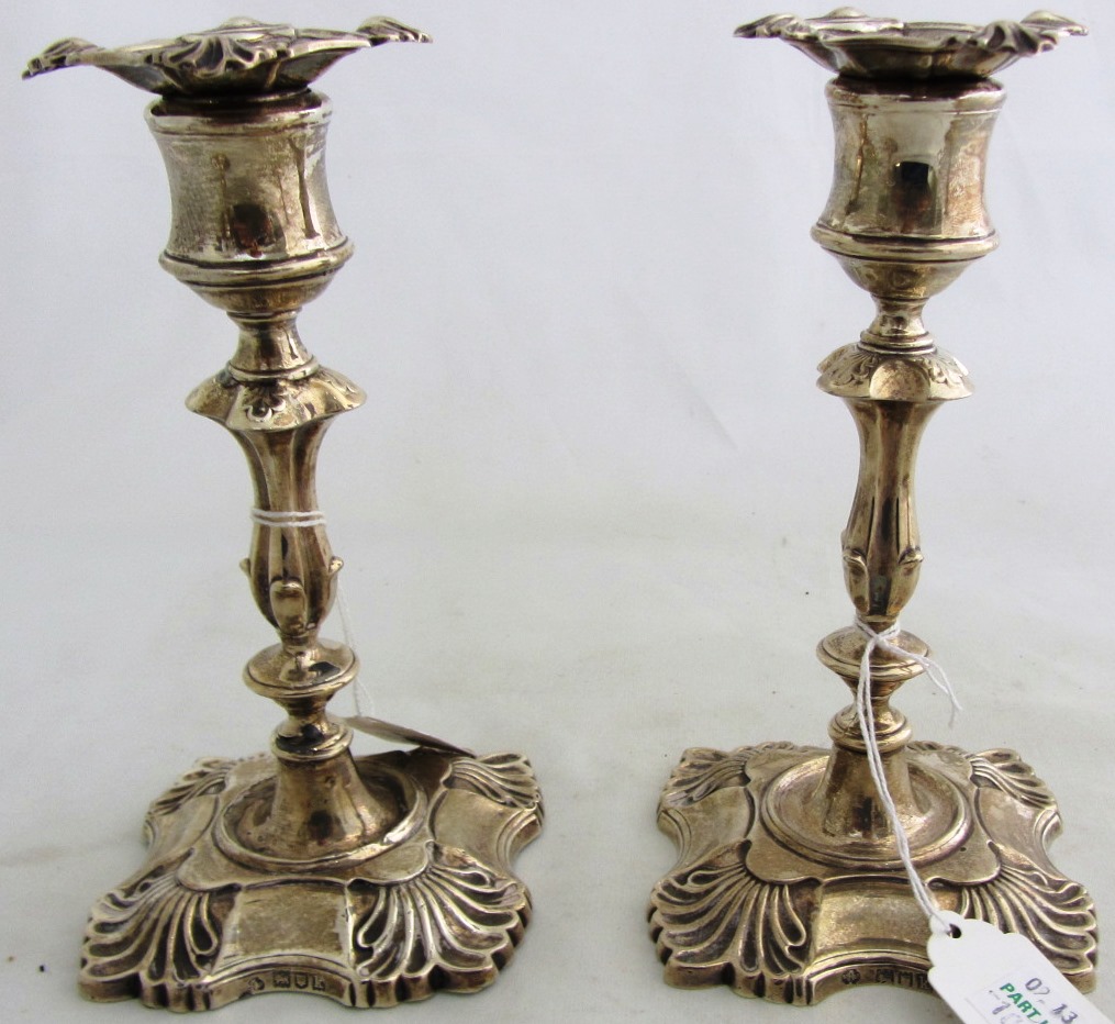 Appraisal: A pair of silver loaded candlesticks each on a shaped