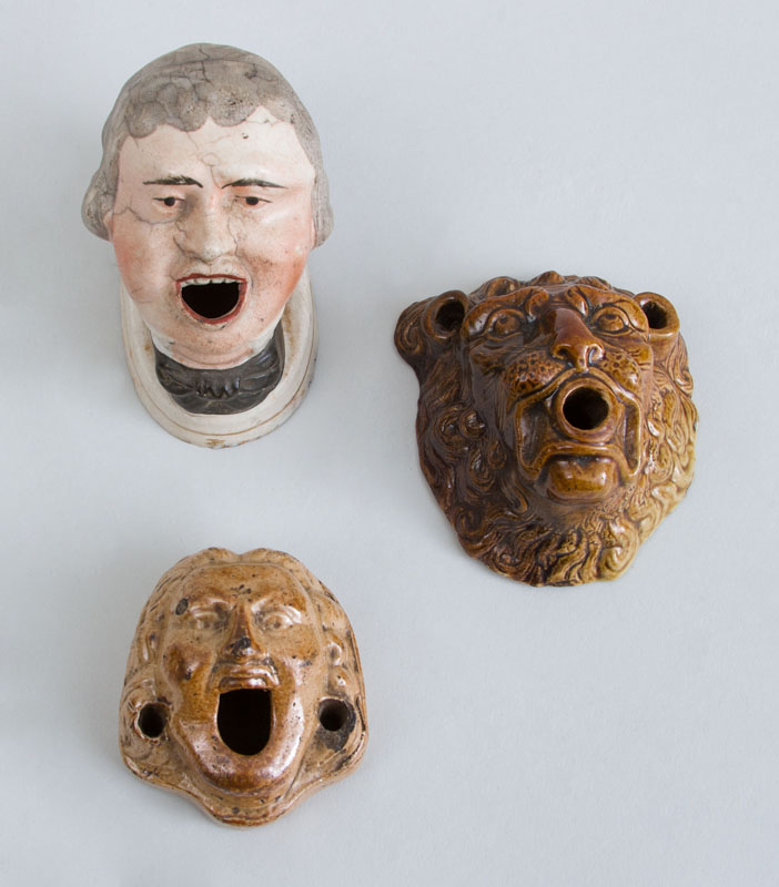 Appraisal: GROUP OF THREE ENGLISH POTTERY MASK HEAD INKWELLS One polychrome