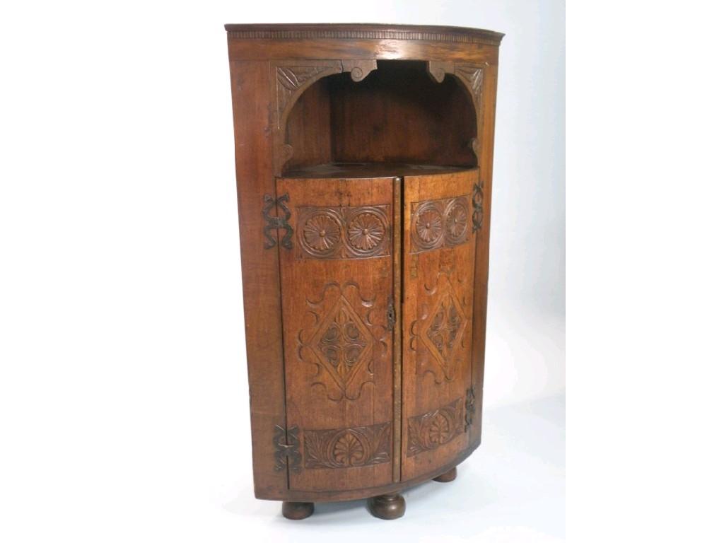 Appraisal: A mahogany and oak bow fronted corner cabinet the top