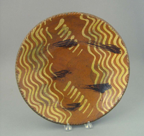 Appraisal: Redware charger th c with yellow slip decoration and black