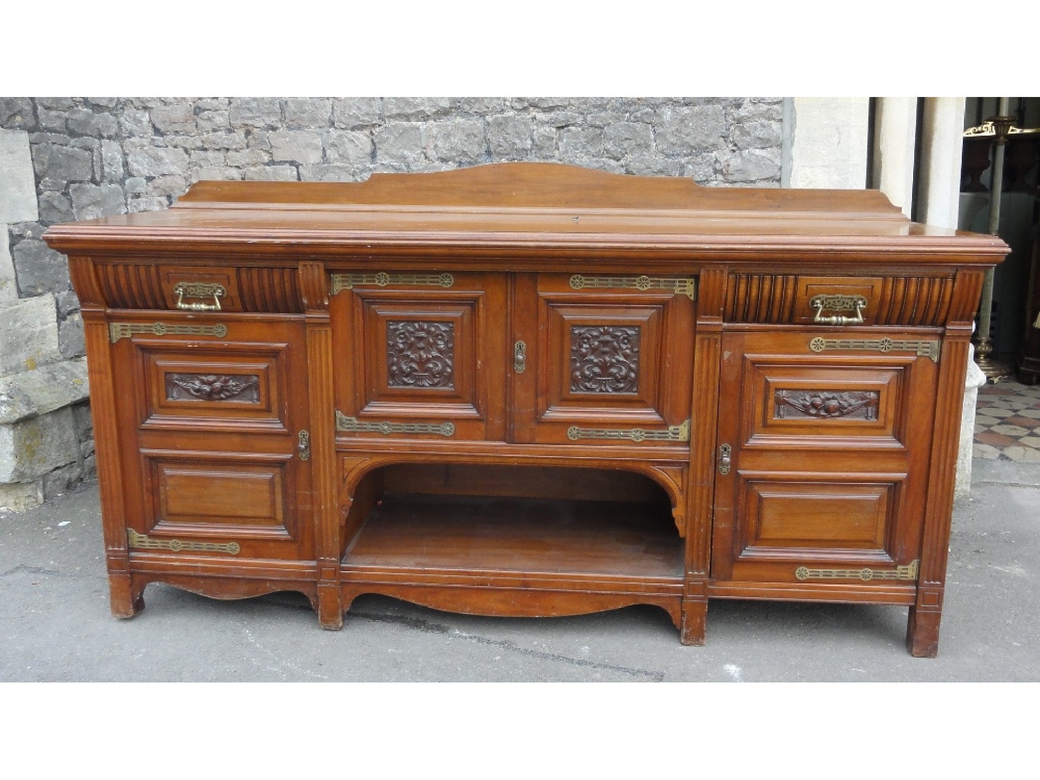 Appraisal: A substantial late Victorian walnut sideboard enclosed by an arrangement