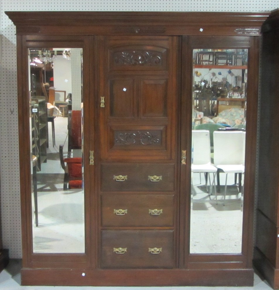 Appraisal: A th century walnut triple wardrobe with a pair of