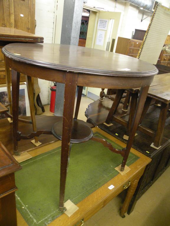 Appraisal: An Edwardian circular two tier occasional table on brass castors