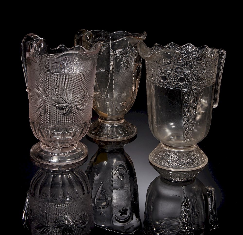 Appraisal: Three Pressed Glass Pitchers Three pressed glass pitchers Dimensions h