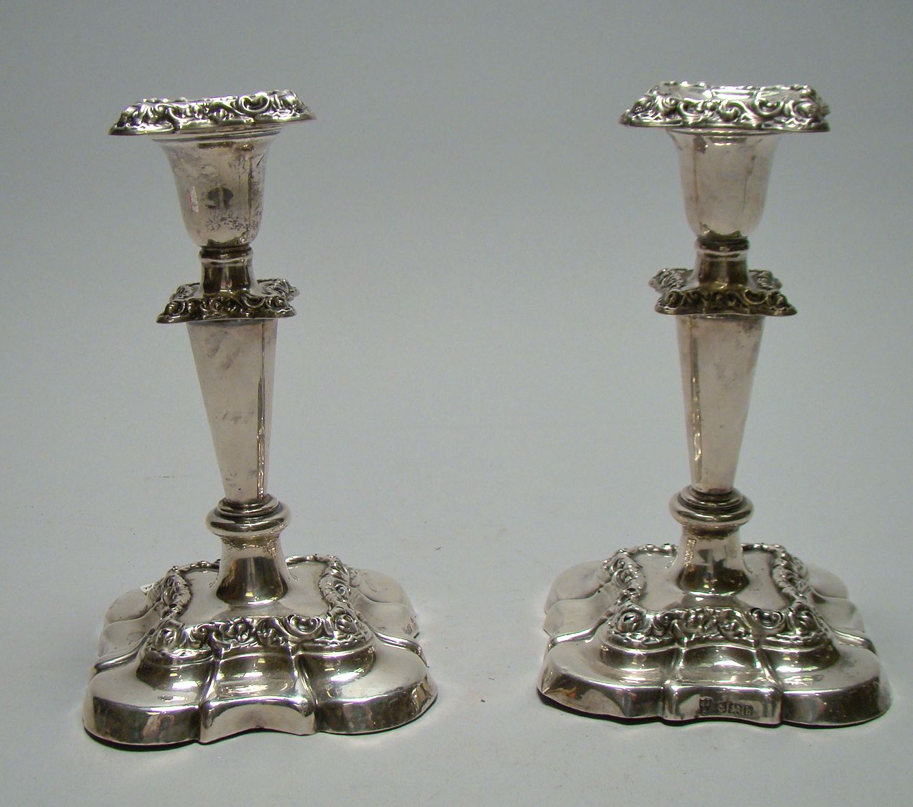 Appraisal: PAIR OF ENGLISH SILVER CANDLESTICKS With chased floral decoration on