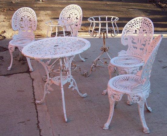 Appraisal: A cast garden suite comprising a table four chairs and