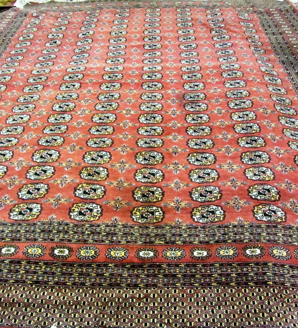 Appraisal: A Pakistan Bokhara carpet the rusty red field with eight