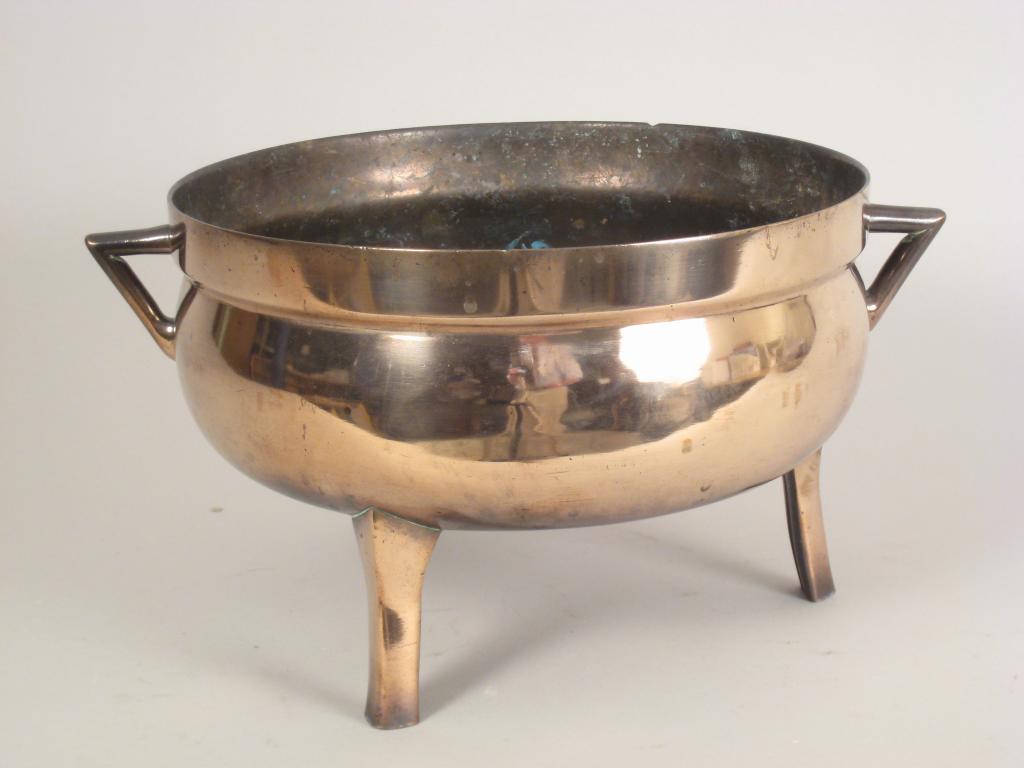 Appraisal: An antique bronze Cauldron with triangular handles on peg feet