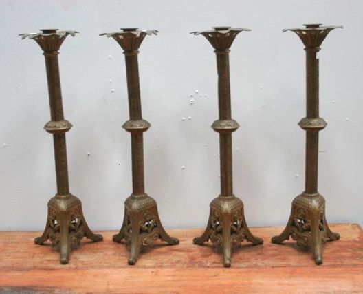 Appraisal: A set of four brass cathedral candlesticks cast with a