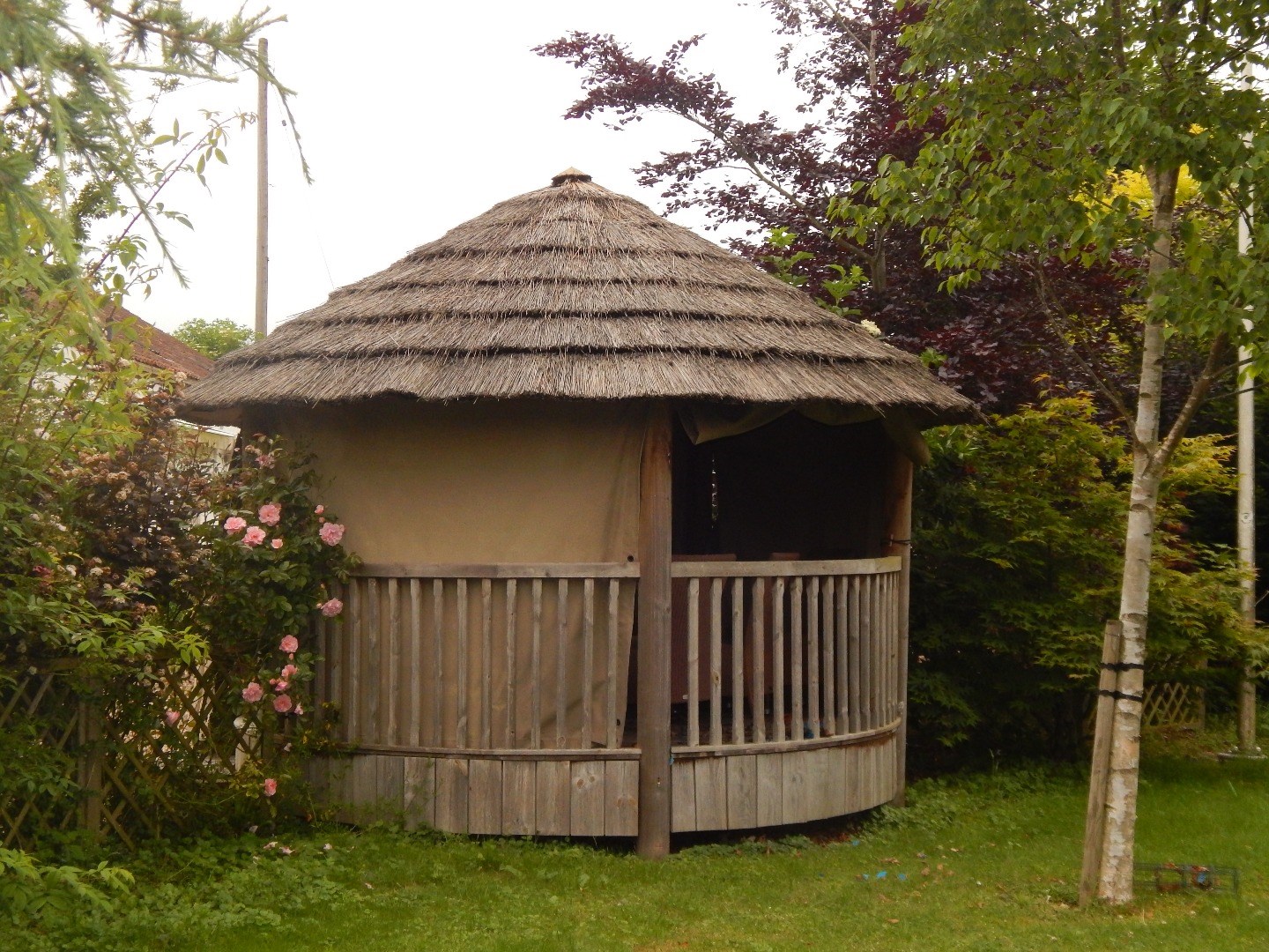 Appraisal: A wooden rotunda of circular form with a thatched roof