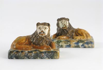 Appraisal: A pair of Prattware lions recumbent on rectangular sponge-decorated bases