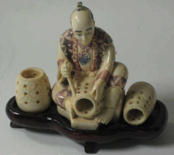 Appraisal: JAPANESE CARVED IVORY SEATED FIGURE Basket weaver polychrome inked robe