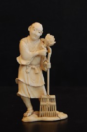 Appraisal: A SIGNED JAPANESE IVORY OKIMONO STANDING WITH RAKE AND LOTUS