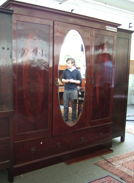 Appraisal: An Edwardian mahogany inlaid triple wardrobe the stepped cornice over