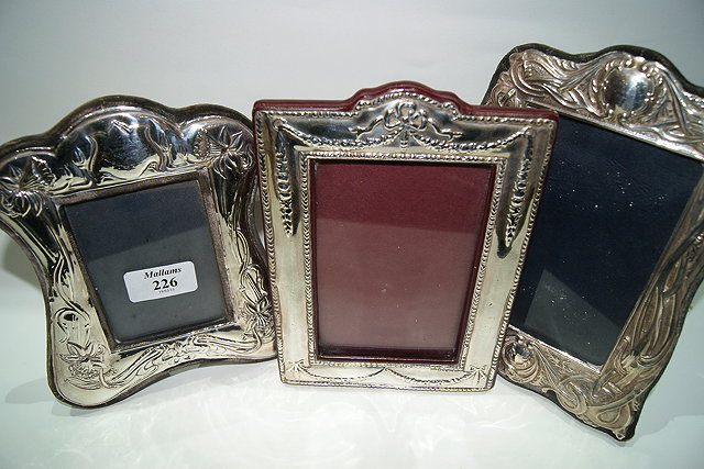 Appraisal: THREE SILVER PHOTOGRAPH FRAMES with embossed relief decoration