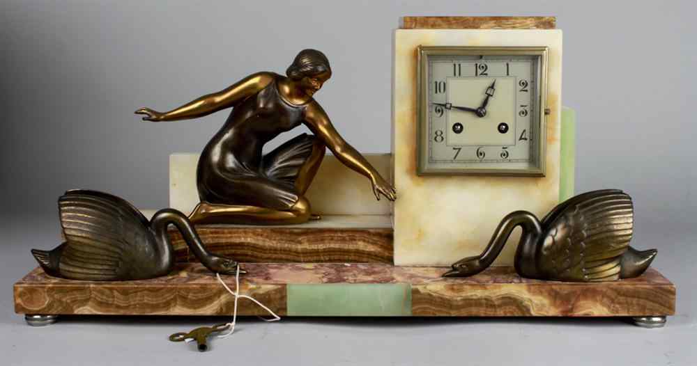 Appraisal: ART DECO CLOCK WITH WOMAN AND TWO SWANS Patinated metal