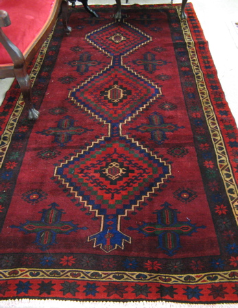 Appraisal: PERSIAN TRIBAL CARPET overall geometric design on red wine ground