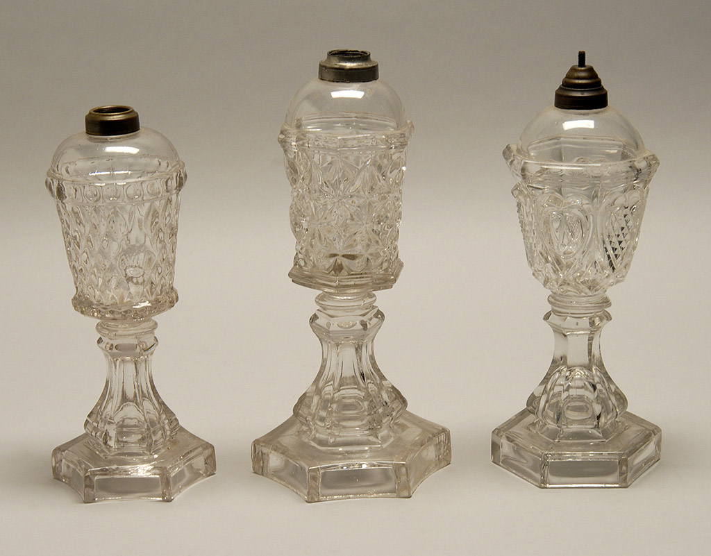 Appraisal: THREE SANDWICH PRESSED COLORLESS GLASS WHALE OIL LAMPS th CenturyA