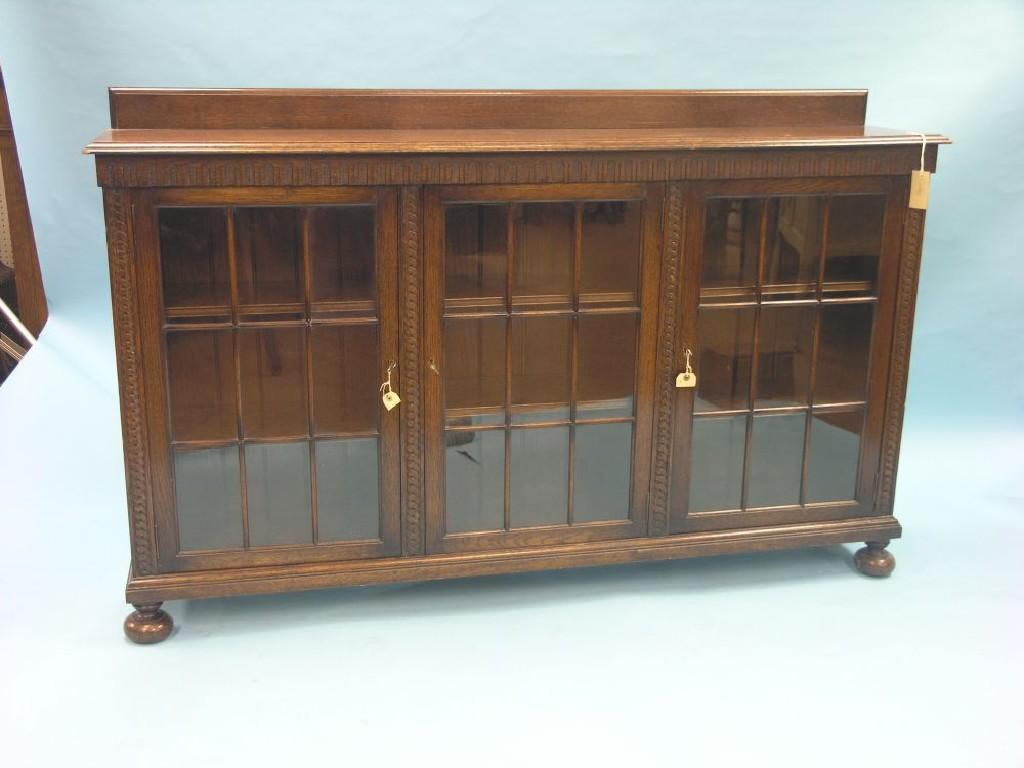 Appraisal: A solid dark oak low bookcase six adjustable shelves enclosed