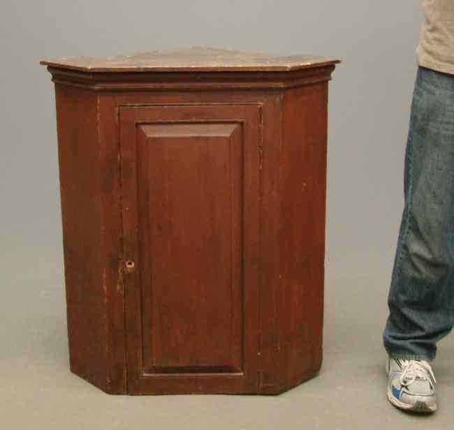 Appraisal: th c single door hanging corner cupboard in red paint