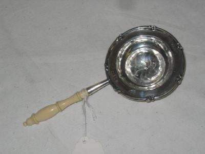 Appraisal: A TEA STRAINER of circular form with leaf moulded rim