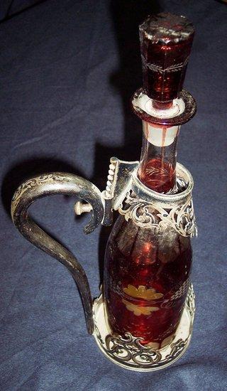 Appraisal: A ruby tinted decanter and stopper the plated stand with