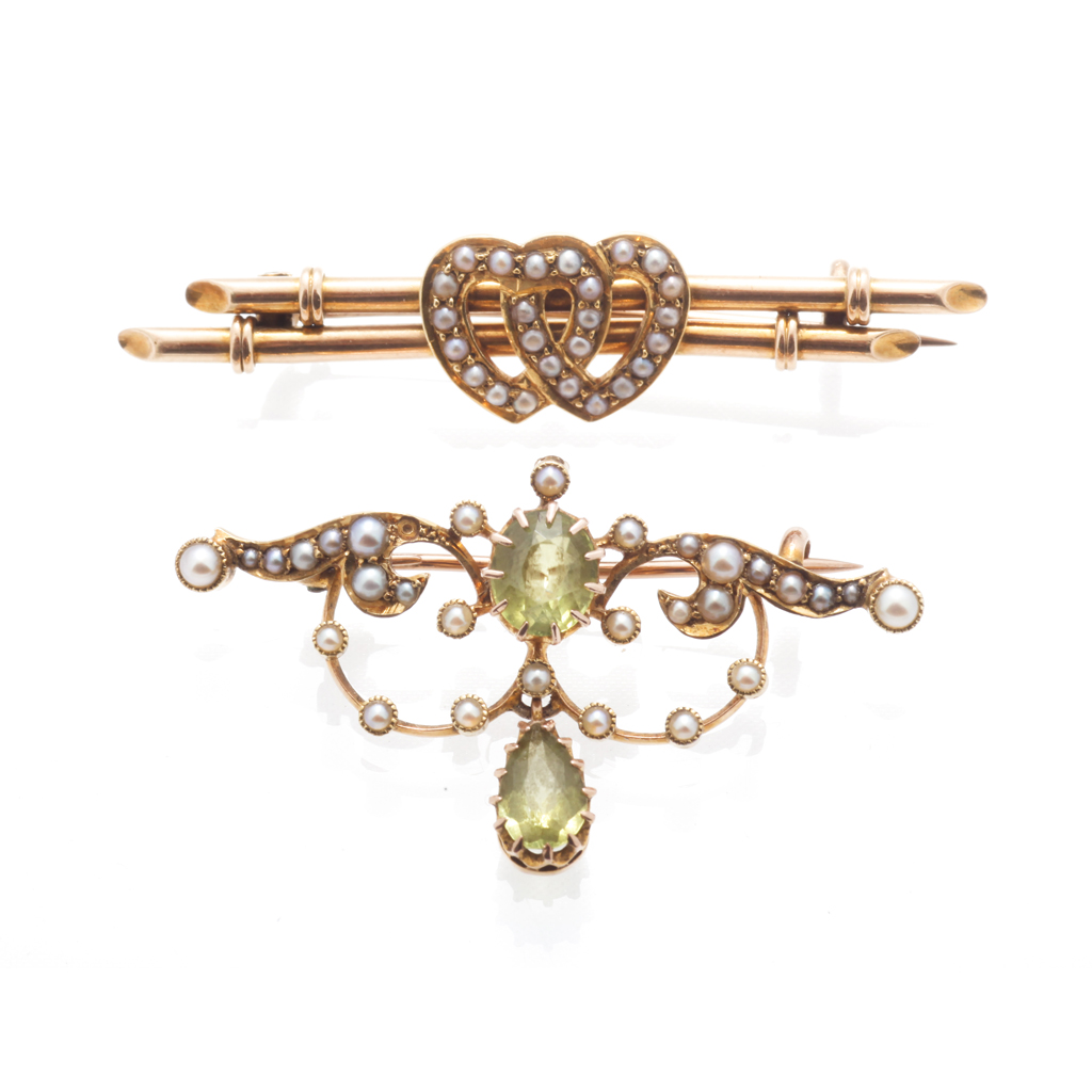 Appraisal: A peridot and seed pearl set brooch of scrolling pierced