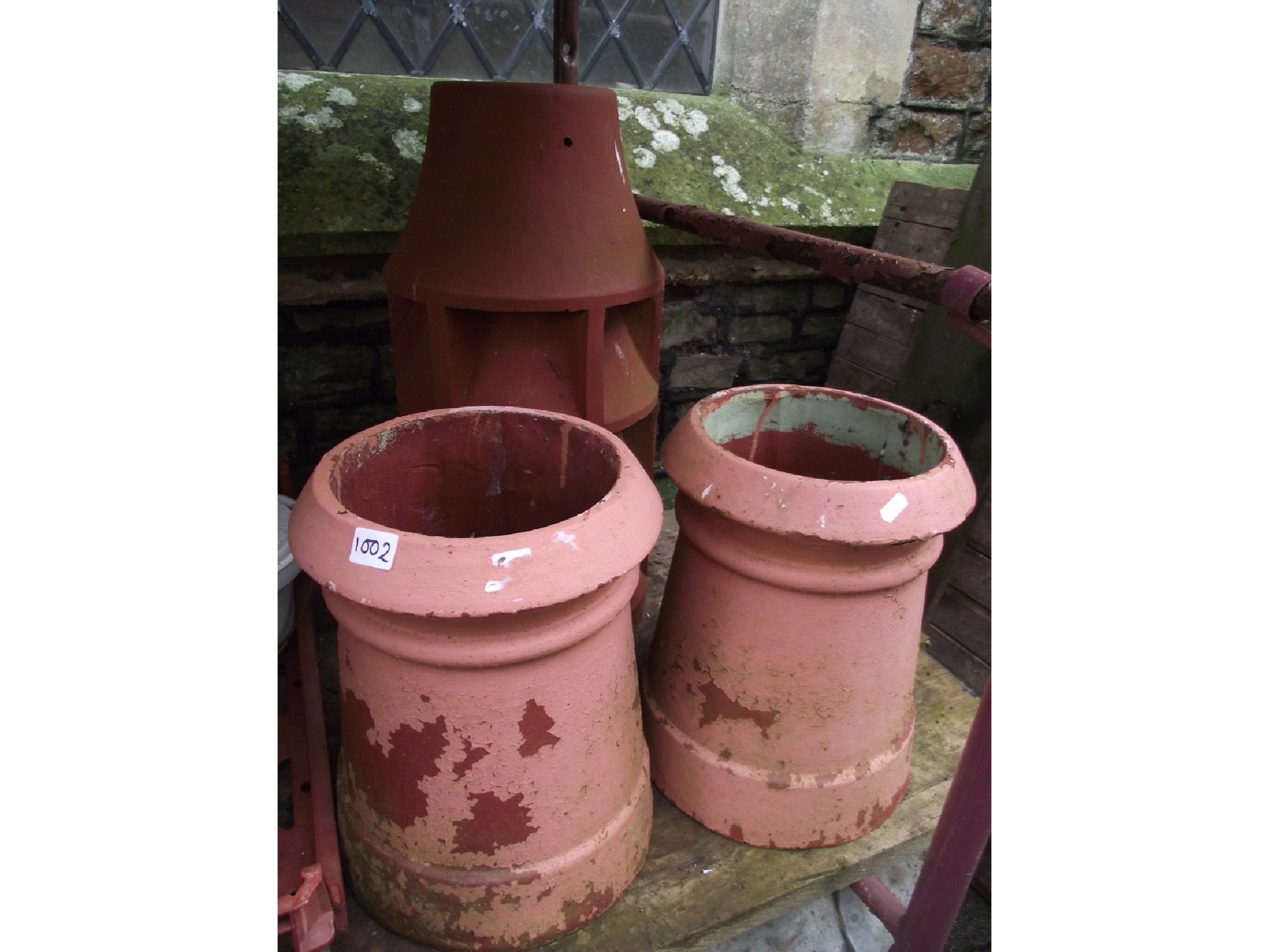 Appraisal: A pair of reclaimed terracotta chimney pots of squat cylindrical