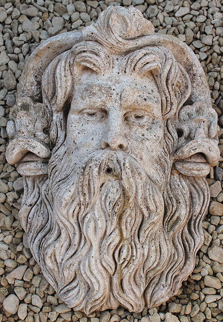 Appraisal: A CAST RECONSTITUTED STONE WALL MOUNTED FOUNTAIN MASK IN THE