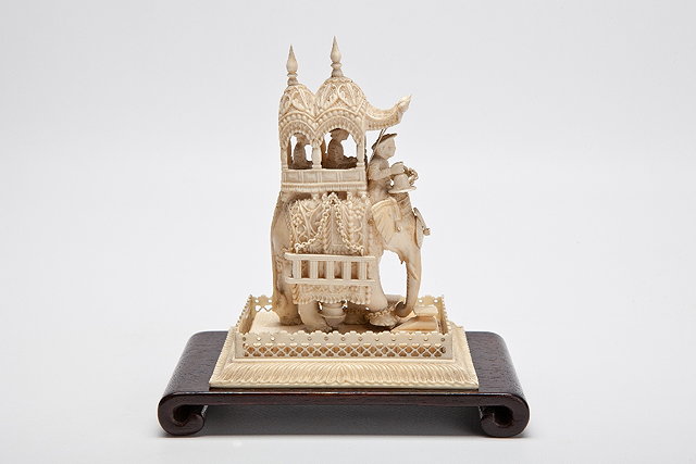 Appraisal: AN INDIAN IVORY CARVING OF AN ELEPHANT carrying an elaborate