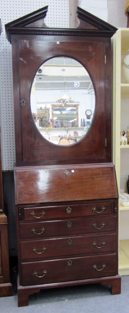 Appraisal: A George III mahogany bureau cabinet with mirrored oval door