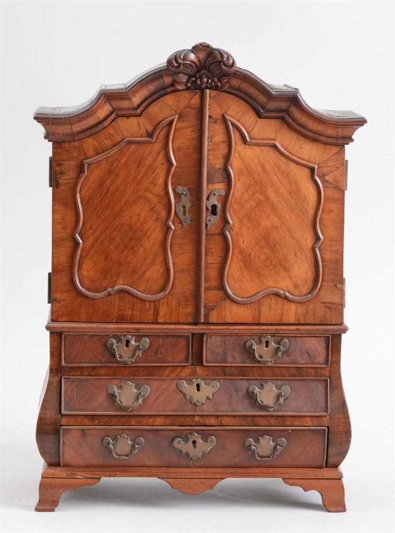 Appraisal: DUTCH ROCOCO STYLE WALNUT MINIATURE BOMB CABINET The shaped crest