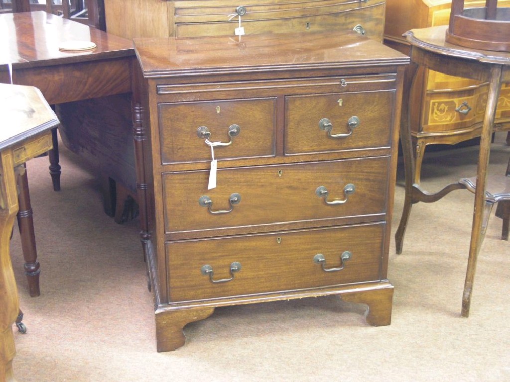 Appraisal: A mahogany chest of drawers brushing slide above two short