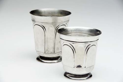 Appraisal: MARIE ZIMMERMANN Two footed tumblers with chased and repousse panels