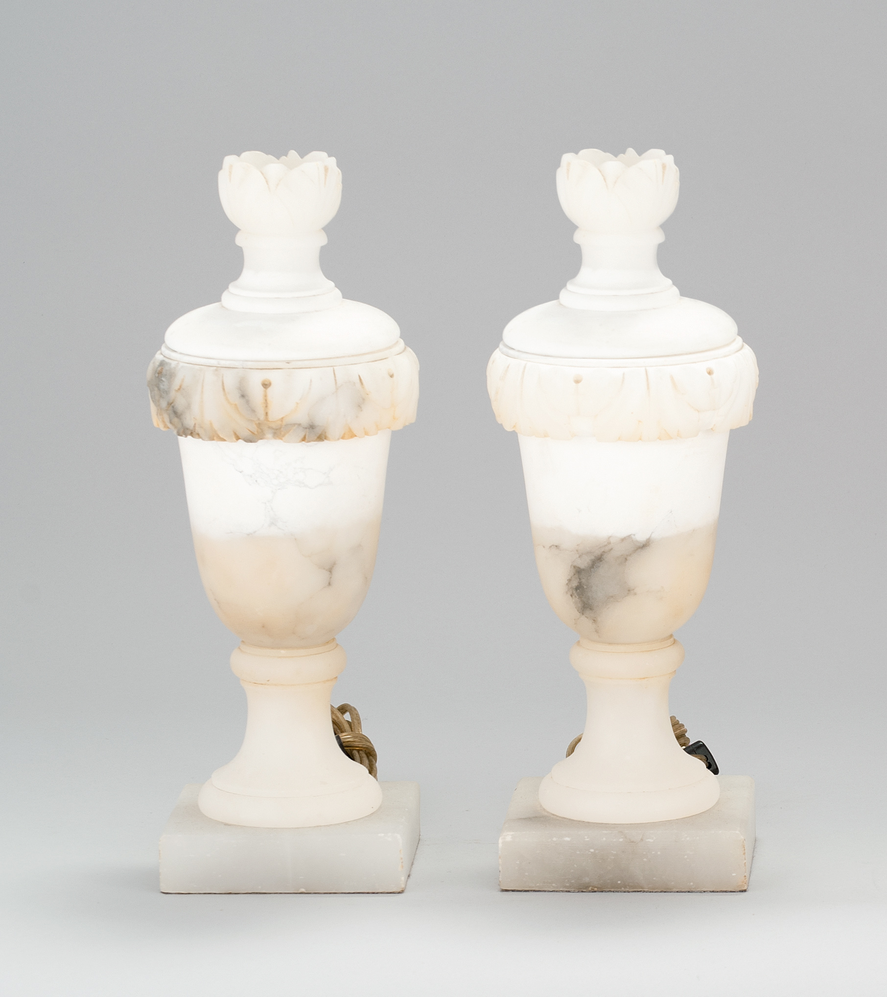 Appraisal: PAIR OF ALABASTER URN-FORM LAMPS Early th CenturyOn square plinths