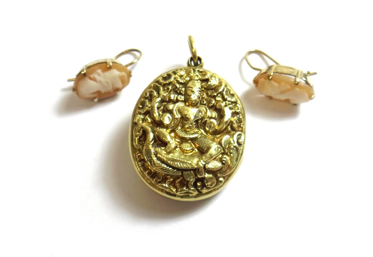 Appraisal: An Eastern gold oval pendant locket decorated with deity figures