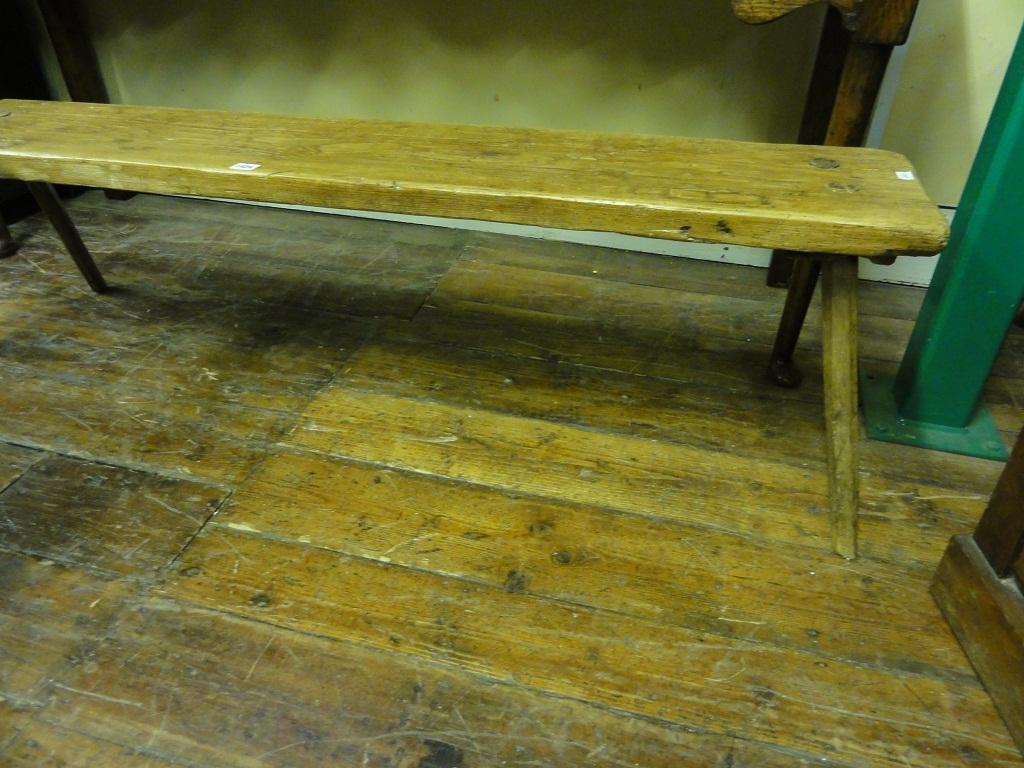 Appraisal: A rustic pine pig bench raised on splayed stick supports