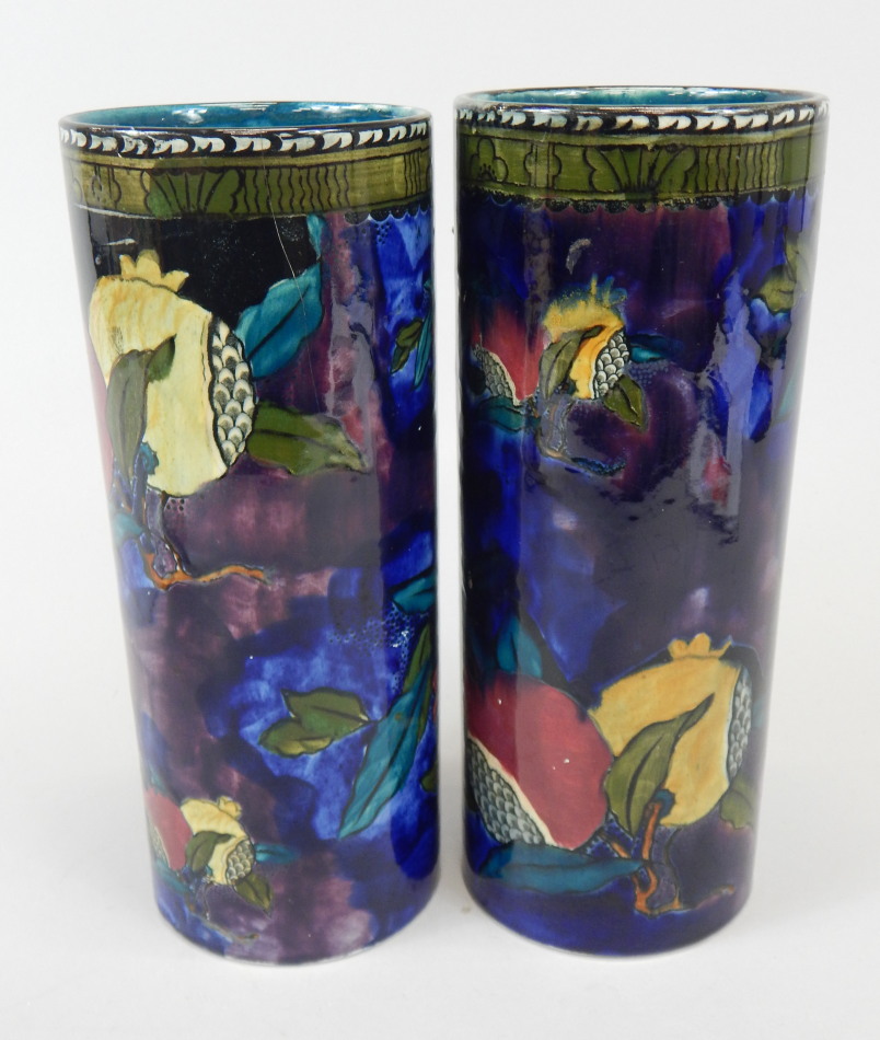 Appraisal: A pair of Rubens ware Pomegranate pattern cylindrical vases designed