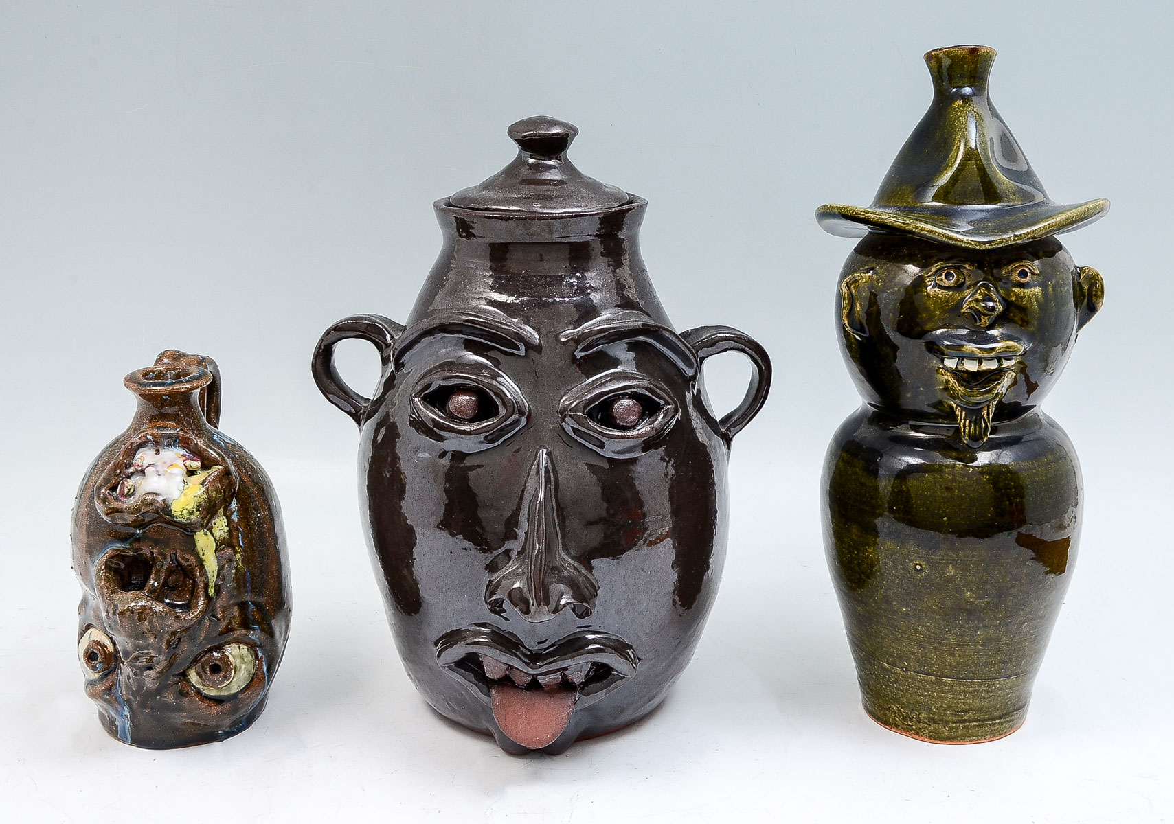 Appraisal: PC FOLK ART POTTERY FACE JUGS Comprising - Tom Pinaud