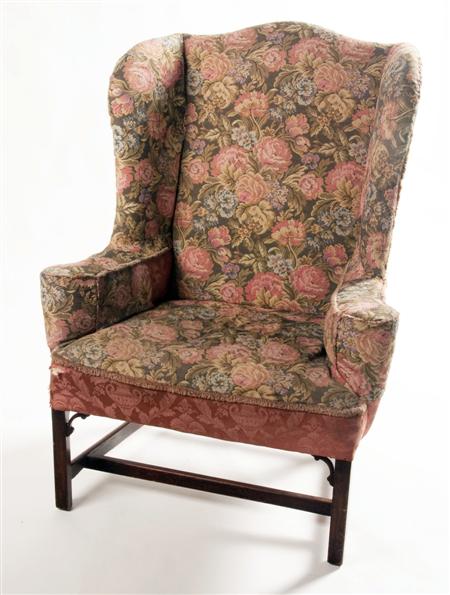 Appraisal: A mahogany framed wing back armchair the cushioned back over