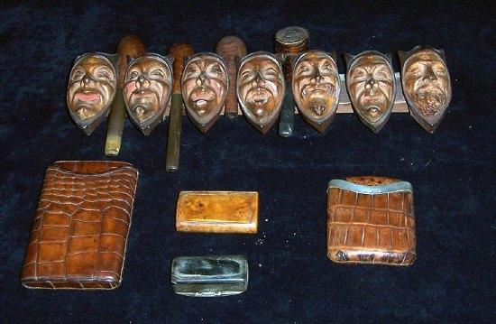 Appraisal: A pipe holder in the form of seven grotesque mask