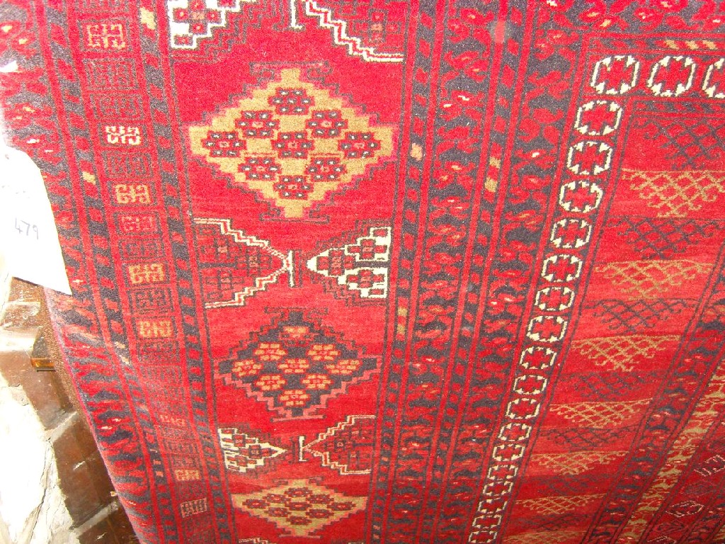 Appraisal: A red ground eastern wool rug with repeating geometric decoration