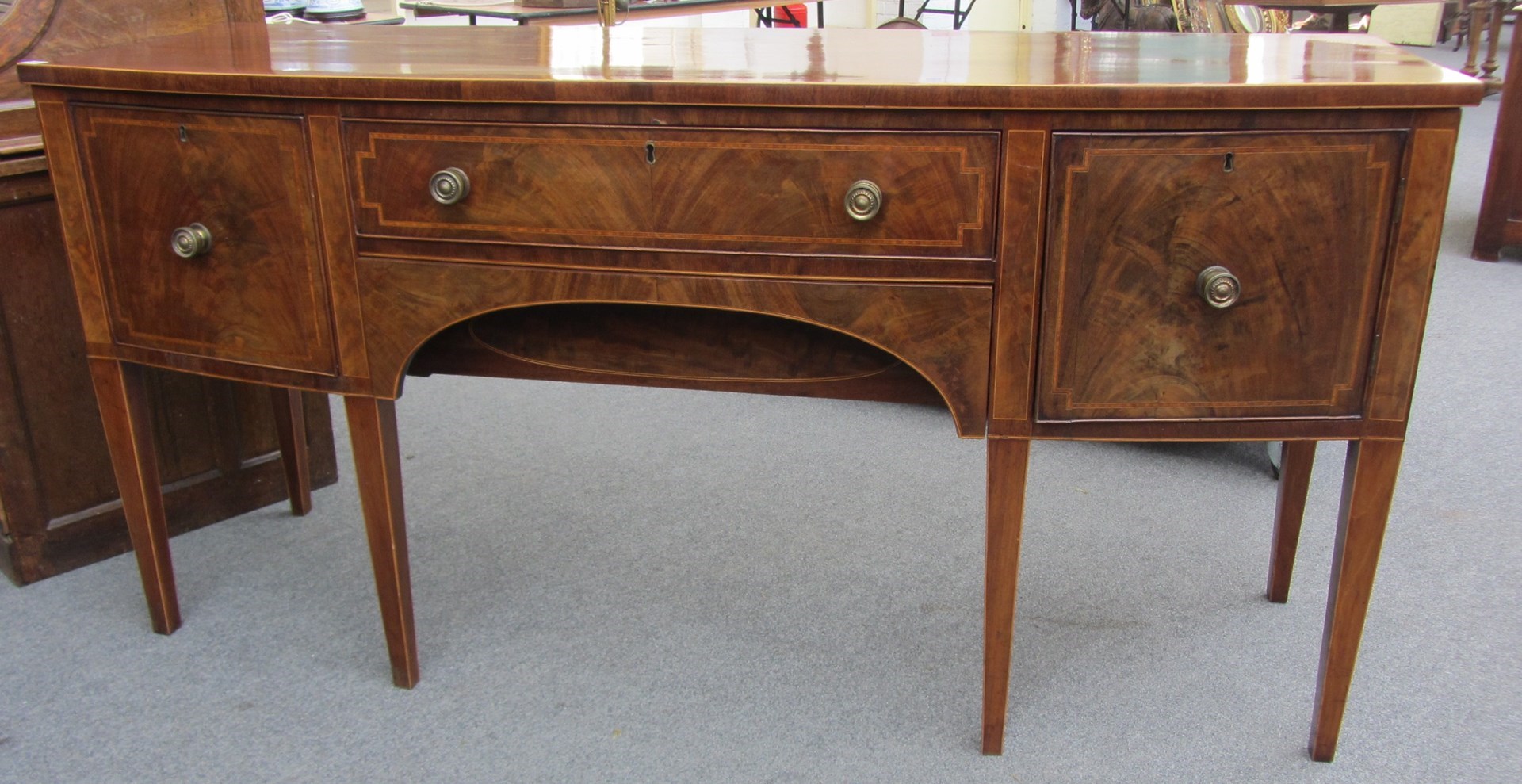 Appraisal: A George III inlaid mahogany bowfront sideboard on tapering square