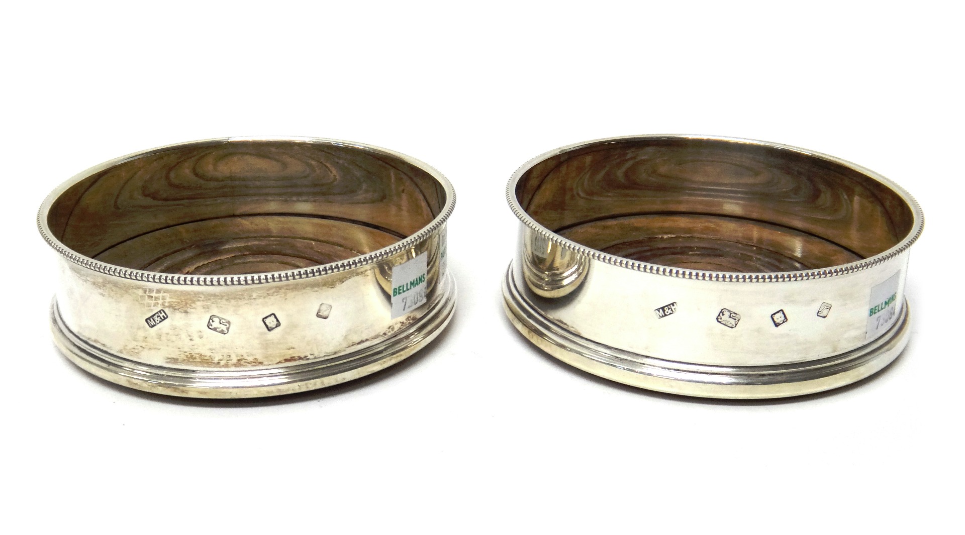 Appraisal: A pair of silver circular bottle coasters each decorated with