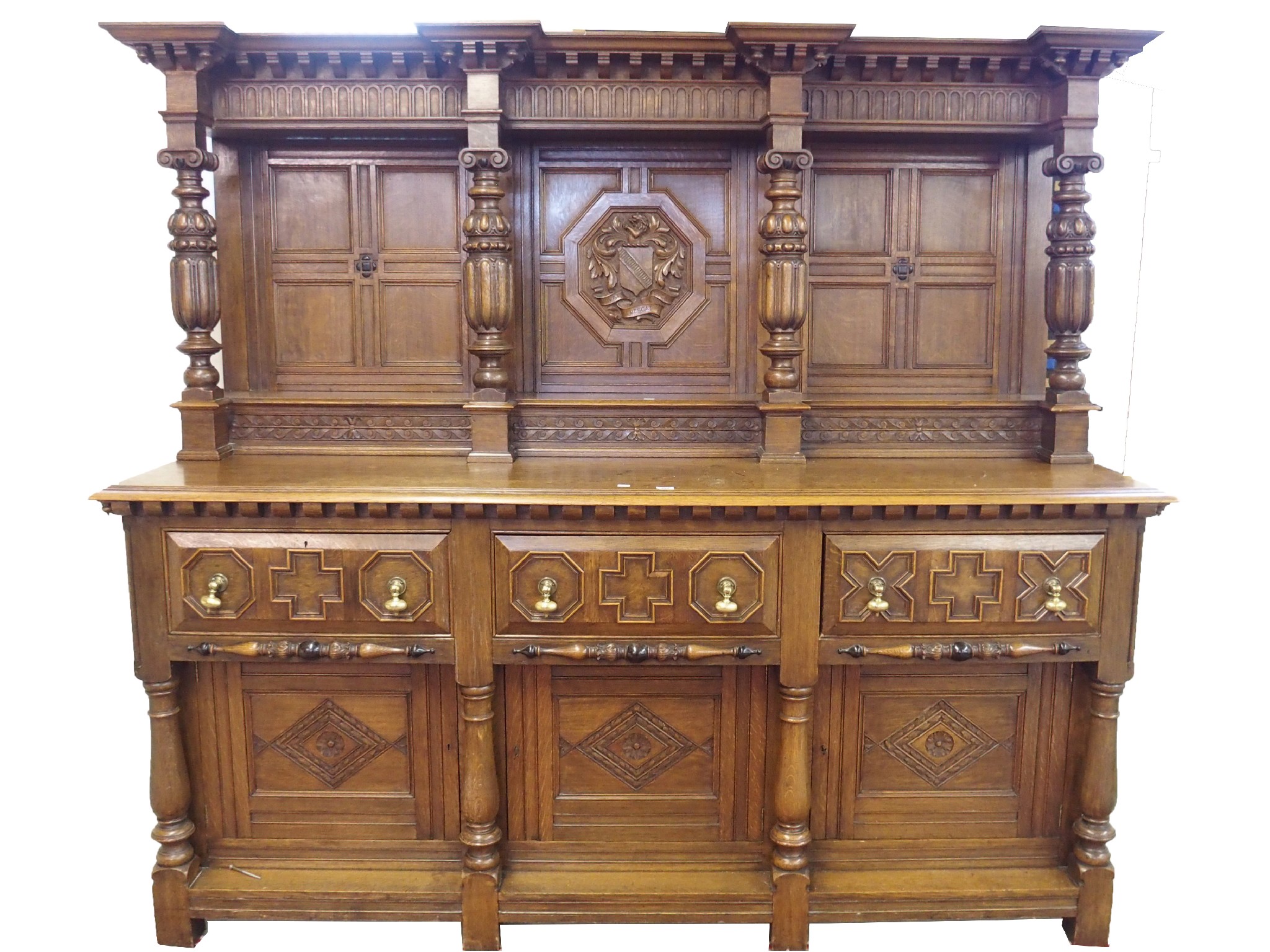 Appraisal: An oak baronial panelled sideboardthe superstructure carved with coat-of-arms and